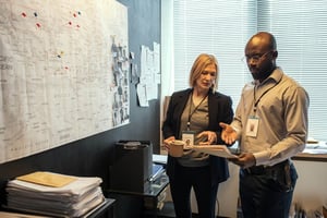 Security analysts reviewing a wall of multi-location maps and notes, illustrating communication fragmentation risks for 2026.